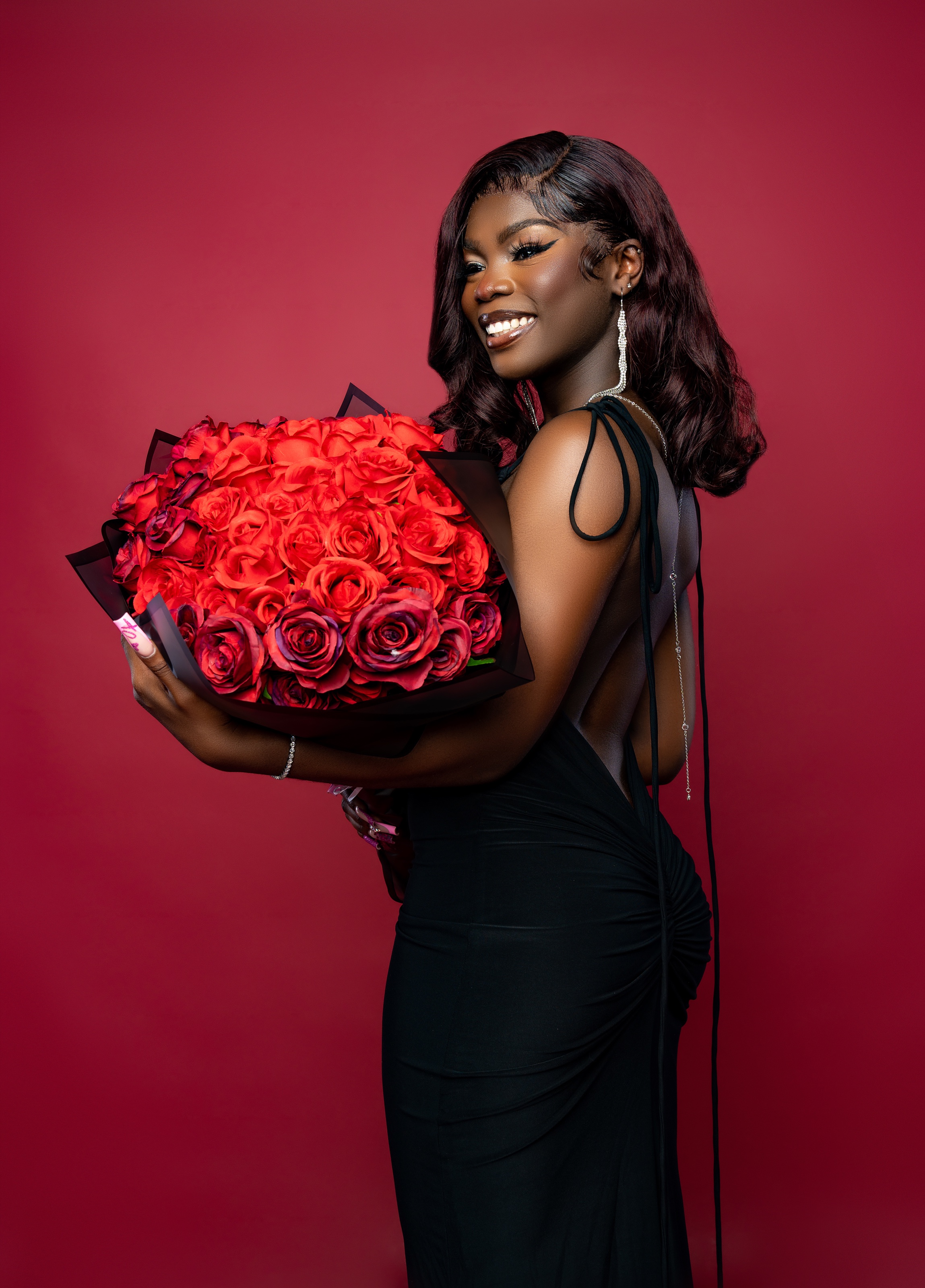 Woman smiling with a bouquet of red roses