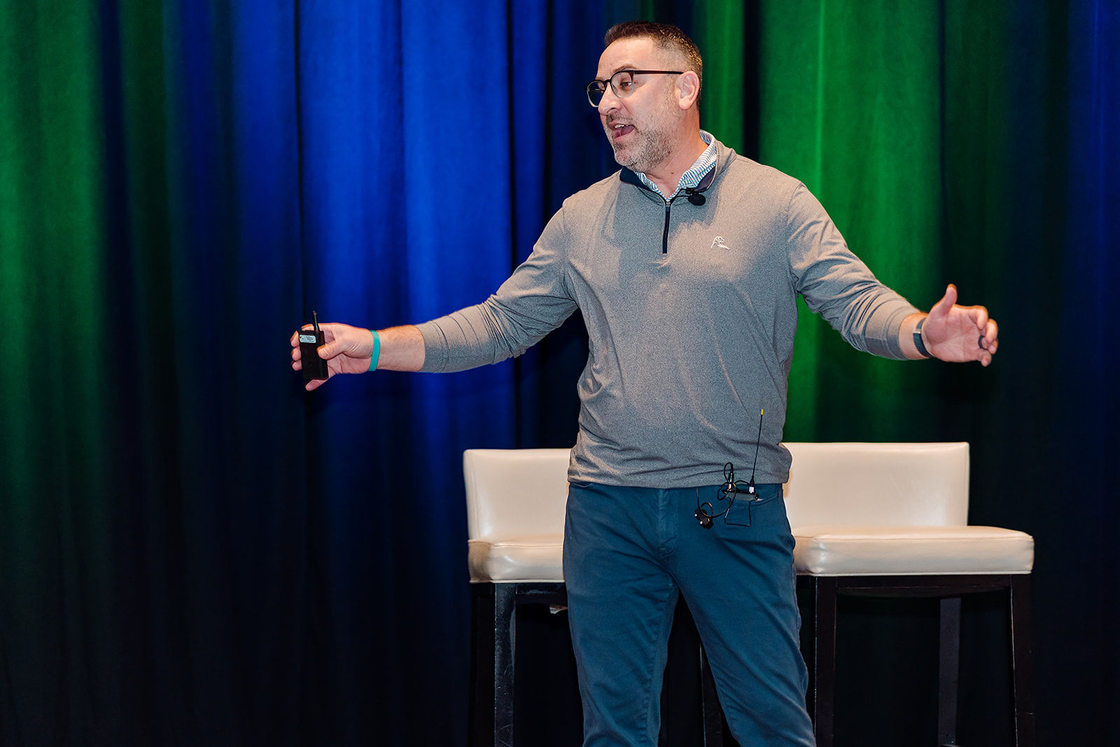 A presenter addresses a corporate audience from a dramatically lit stage